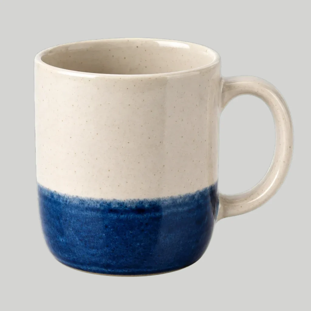 Cream ceramic mug with a blue base photographed on a gray background — Original